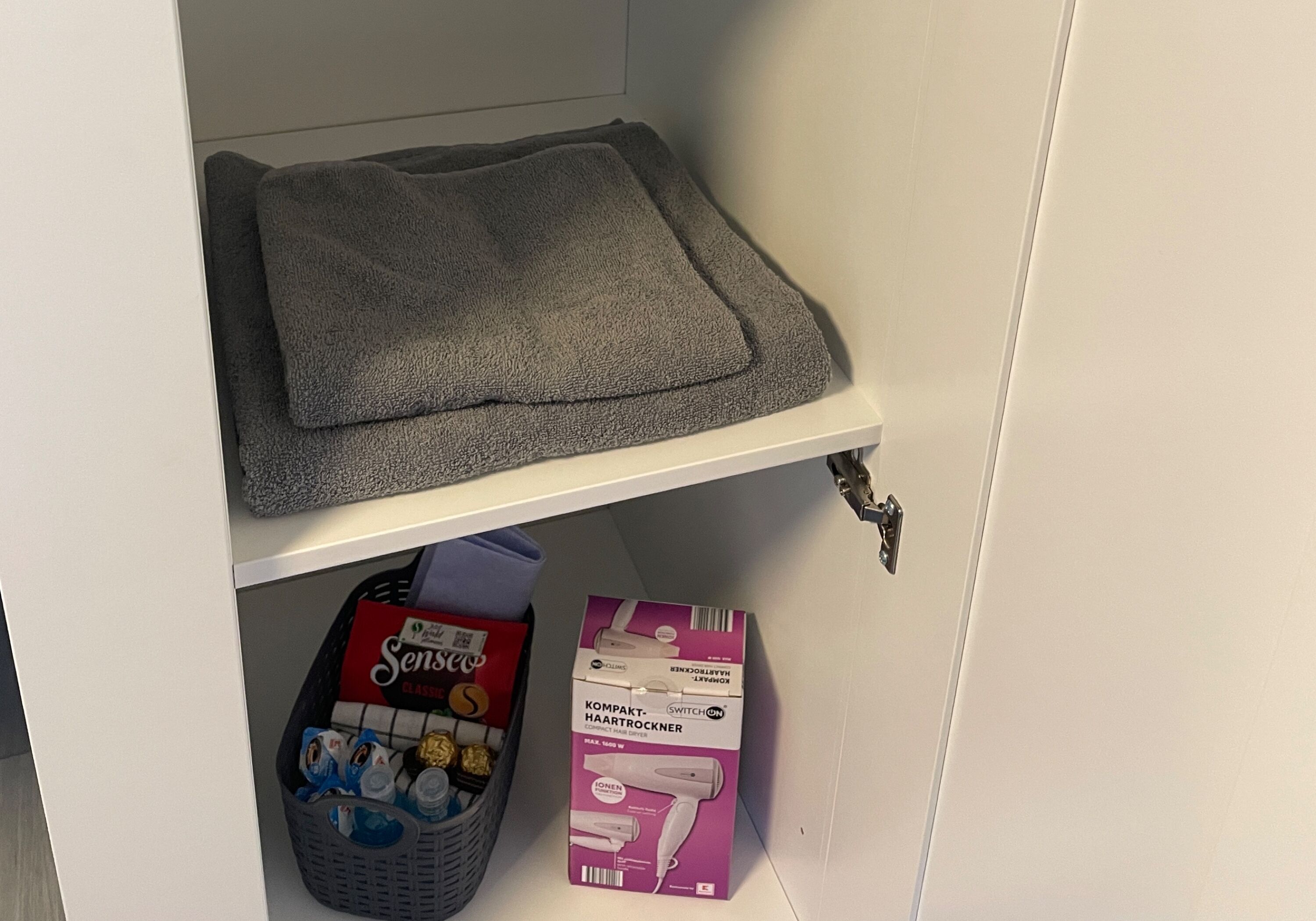 Bereitgelegte Handtücher, Kaffee und Pflegeartikel im Schrank